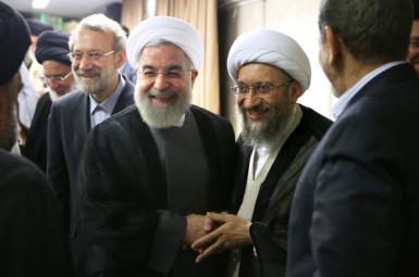 Former Iranian President Hassan Rouhani shaking hands with Amoli Larijani, with Ali Larijani on the left. Undated