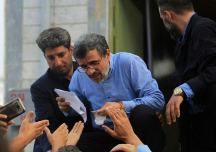 Iran's former president Mahmoud Ahmadinejad reading petitions during one his trips to regions. Undated